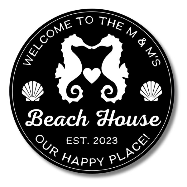 The Personalized Custom Round Beach House Sign features white text and graphics on a black background: Welcome to the M & Ms Beach House, Est. 2023. Our Happy Place! with two seahorses facing each other and a heart between them, surrounded by seashells.