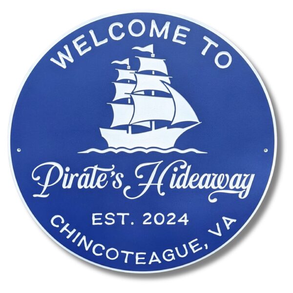 A round, blue beach house sign with white text says: Welcome to Pirates Hideaway. Est. 2024. Chincoteague, VA. Above the words is an illustration of a majestic sailing ship, capturing the spirit of adventure—a perfect addition to your Personalized Custom Round Beach House Sign Coastal Decor.