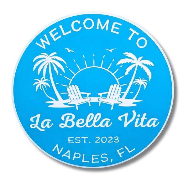 The Personalized Custom Beach House Sign features a blue background with white text saying WELCOME TO La Bella Vita EST. 2023 NAPLES, FL, decorated with palm trees, a sun, birds, and beach chairs. Perfect for fans of coastal decor.