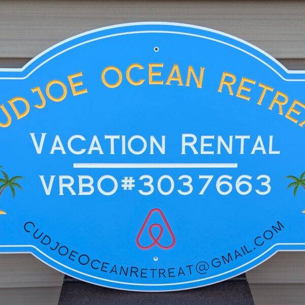 Blue sign displaying Cudjoe Ocean Retreat, Vacation Rental, VRBO#3037663, with a custom palm tree design and email: cudjoeoceanretreat@gmail.com. Perfect for rentals, this bordered sign suits any wood-paneled backdrop. Product: Custom Signs for Homes & Rentals, VRBO, STR.