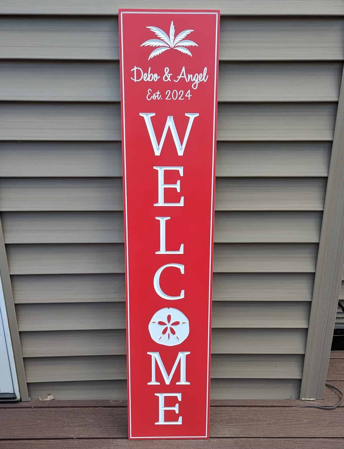 welcome sign with sand dollar red