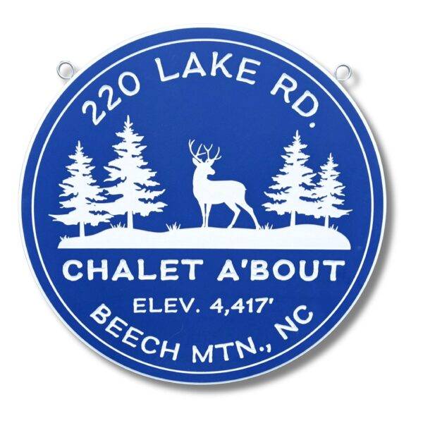 A circular blue pvc sign with white text and silhouettes of a deer and three trees exudes rustic charm. Reading 220 Lake Rd., Chalet A'Bout, Elev. 4,417, Beech Mtn., NC, its perfect for any nature lovers gallery. Two small metal loops at the top make it easy to hang.