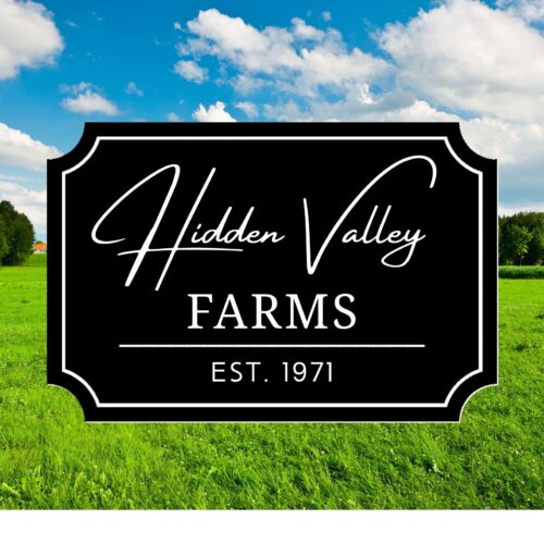 A black sign with white text reading Hidden Valley Farms, Est. 1971 stands in a green field and blue sky, evoking the Personalized Oval Beach House Sign – Custom Coastal Decor for Your Beachfront Home.